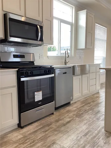 a kitchen with stainless steel appliances a stove a microwave a sink and cabinets