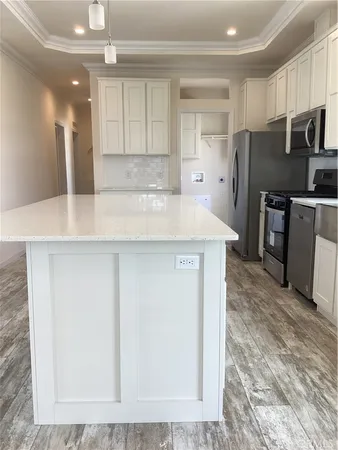 a kitchen with kitchen island a counter top space cabinets and stainless steel appliances