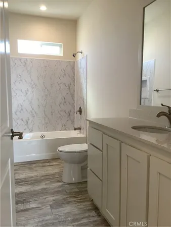 a bathroom with a granite countertop toilet a sink and bathtub