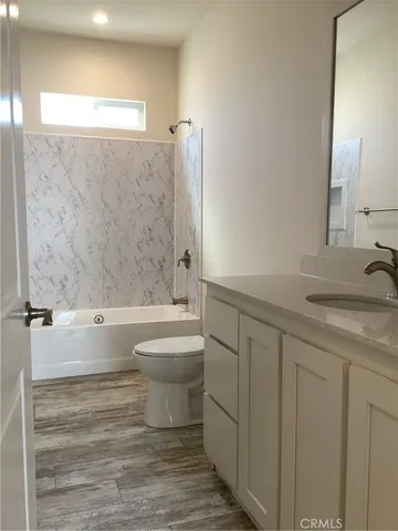 a bathroom with a granite countertop toilet a sink and bathtub