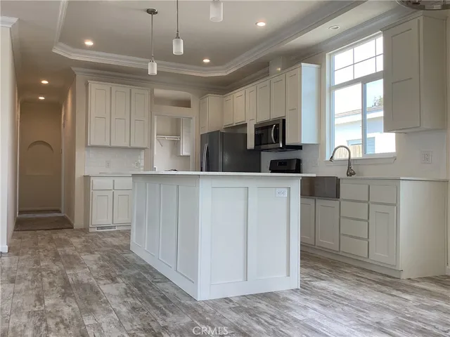 a kitchen with white cabinets and refrigerator