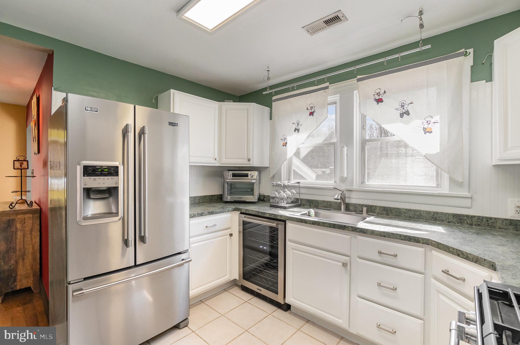 5813 Ebenezer Road White Marsh, MD 21162 - Photo 14 of 46 a kitchen with granite countertop white cabinets white stainless steel appliances a sink and a window