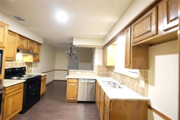 a large kitchen with a sink stove top oven and cabinets