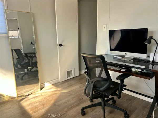 a view of a workspace with furniture and wooden floor