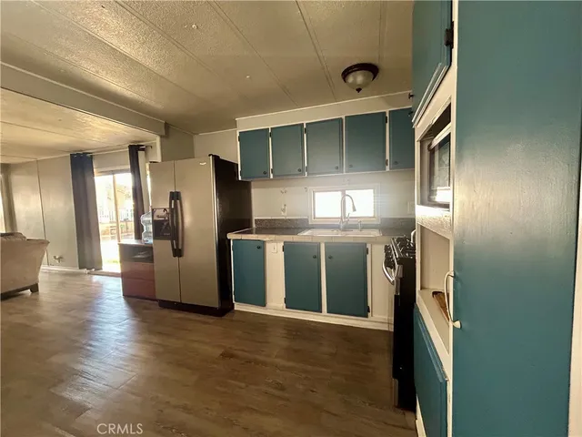 a view of a kitchen with a sink and a refrigerator