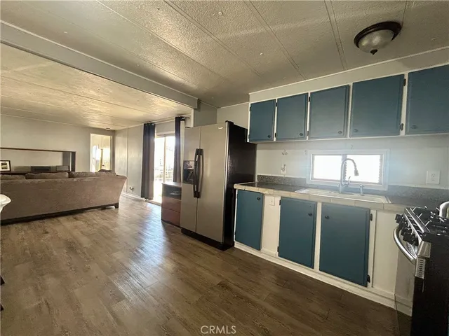 a kitchen with stainless steel appliances granite countertop a sink a stove and a wooden floors