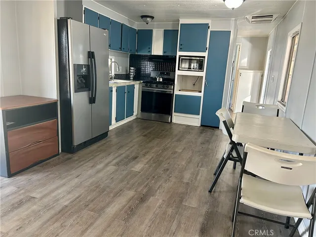 a kitchen with stainless steel appliances granite countertop a refrigerator and a stove top oven