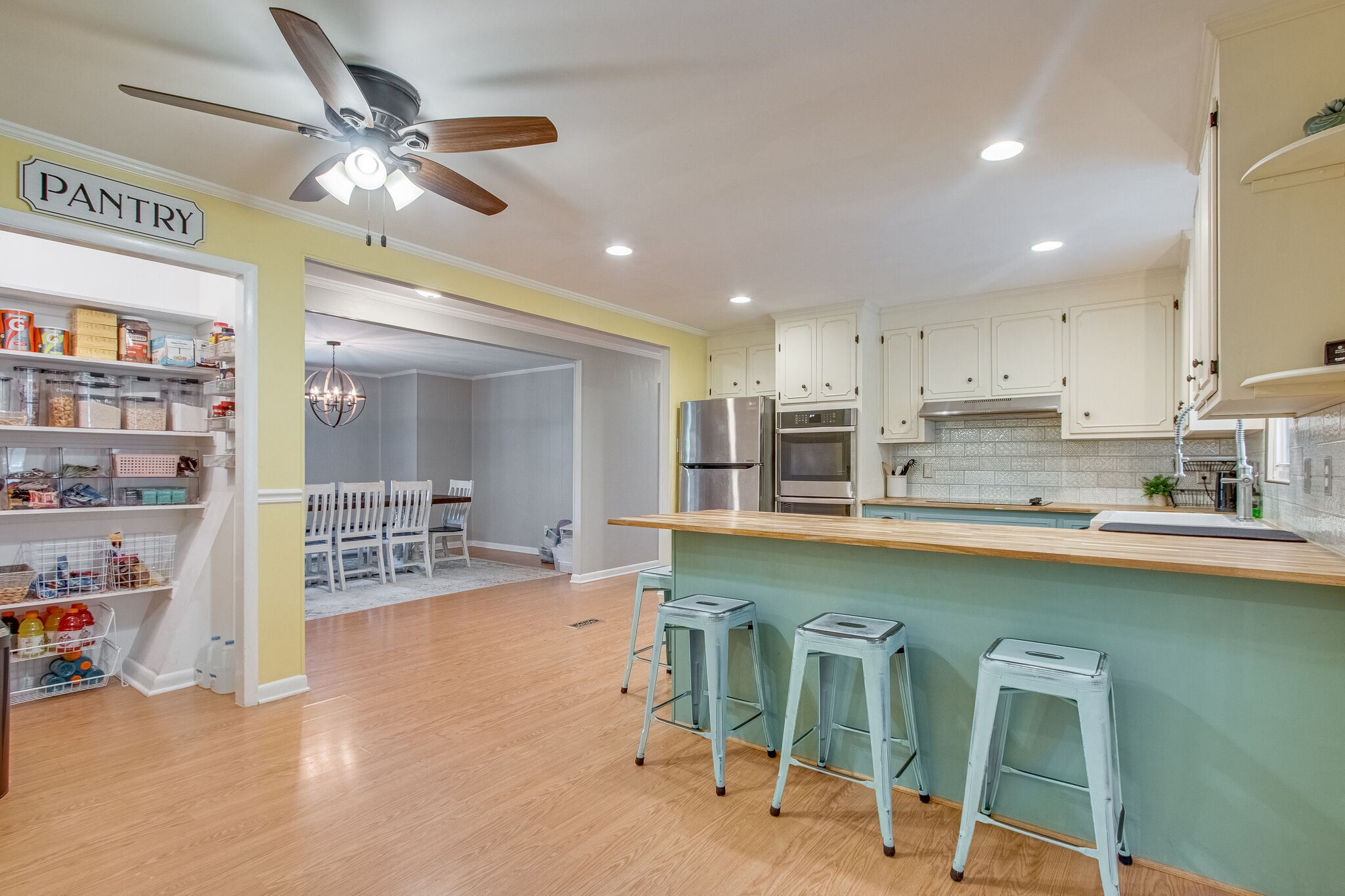 4543 South Carothers Road Franklin, TN 37064 - Photo 9 of 34 a kitchen with stainless steel appliances granite countertop a stove top oven a refrigerator a dining table and chairs with wooden floor