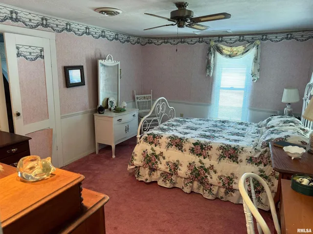 a bedroom with a bed and dresser with mirror