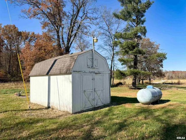 a backyard of a house with wooden fence and a tree