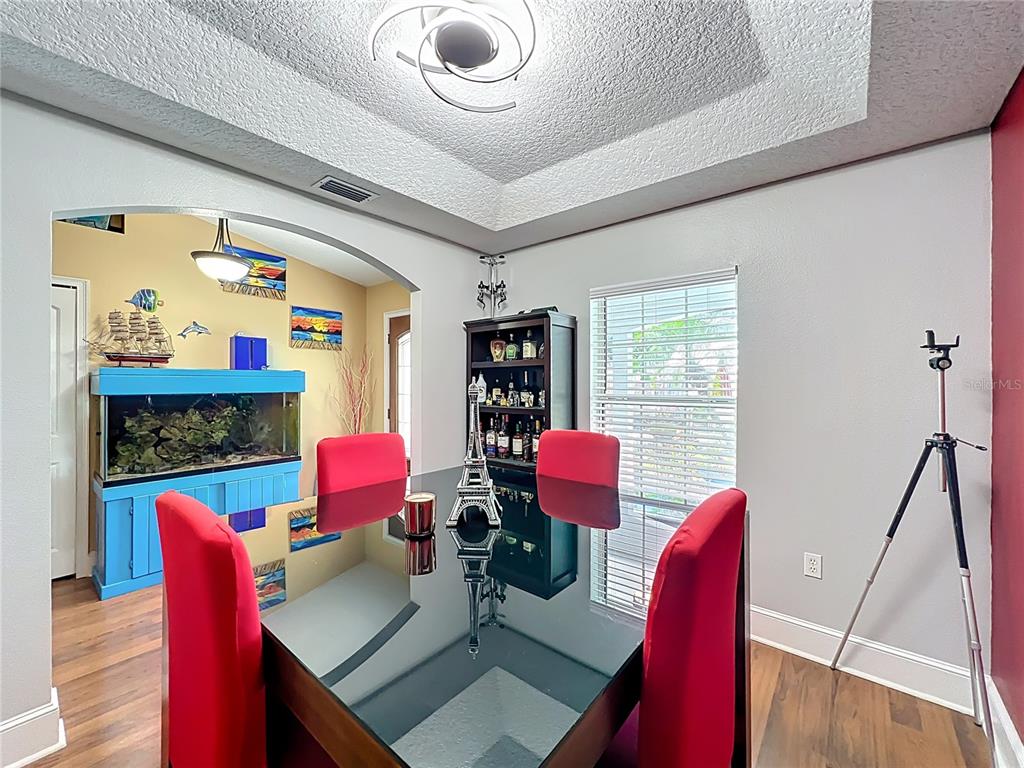 1312 Perkins Road Orlando, FL 32809 - Photo 15 of 80 a view of a dining room with furniture a chandelier and wooden floor