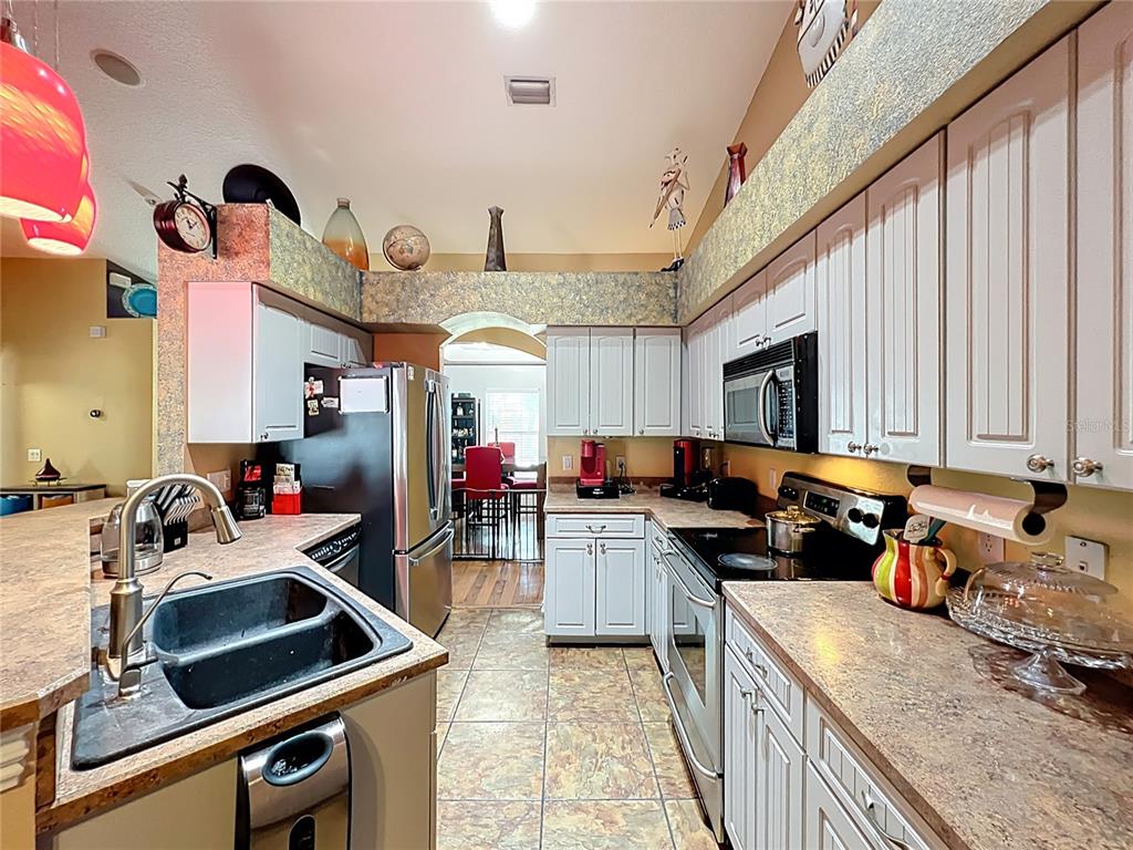 1312 Perkins Road Orlando, FL 32809 - Photo 31 of 80 a kitchen that has a lot of cabinets a sink and a stove in it