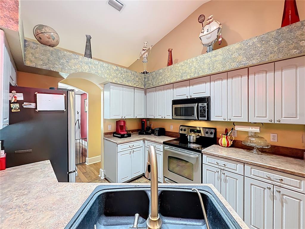 1312 Perkins Road Orlando, FL 32809 - Photo 32 of 80 a kitchen with stainless steel appliances a stove a sink dishwasher and cabinets with wooden floor