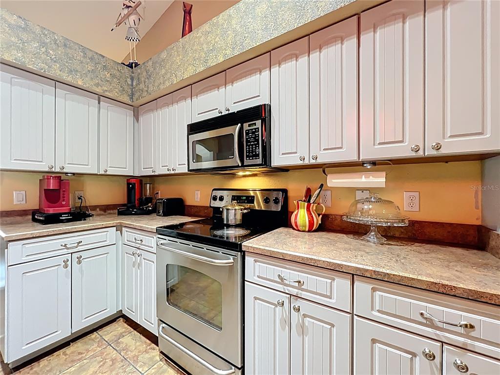 1312 Perkins Road Orlando, FL 32809 - Photo 33 of 80 a kitchen with stainless steel appliances granite countertop a sink a stove and cabinets