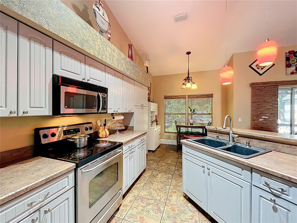 1312 Perkins Road Orlando, FL 32809 - Photo 34 of 80 a kitchen with stainless steel appliances a sink a stove and a microwave