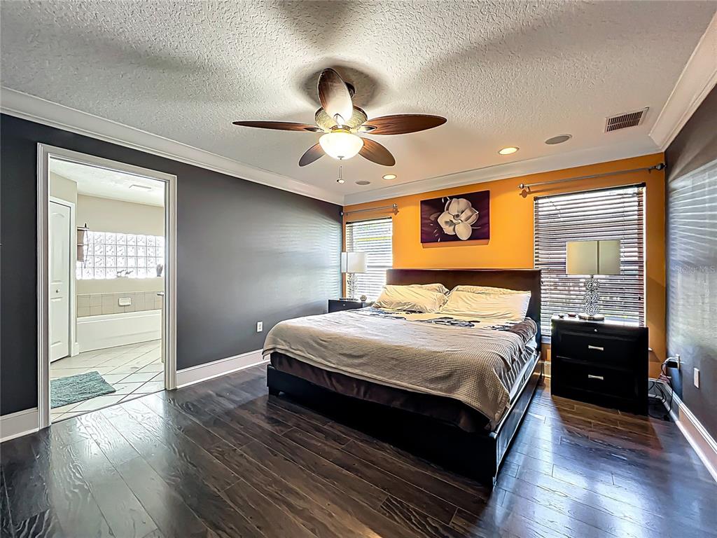 1312 Perkins Road Orlando, FL 32809 - Photo 35 of 80 a bedroom with a large bed and a chandelier fan