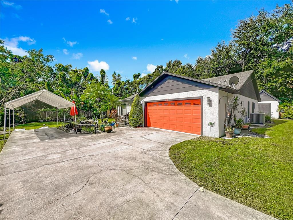 1312 Perkins Road Orlando, FL 32809 - Photo 66 of 80 a front view of a house with a yard and garage