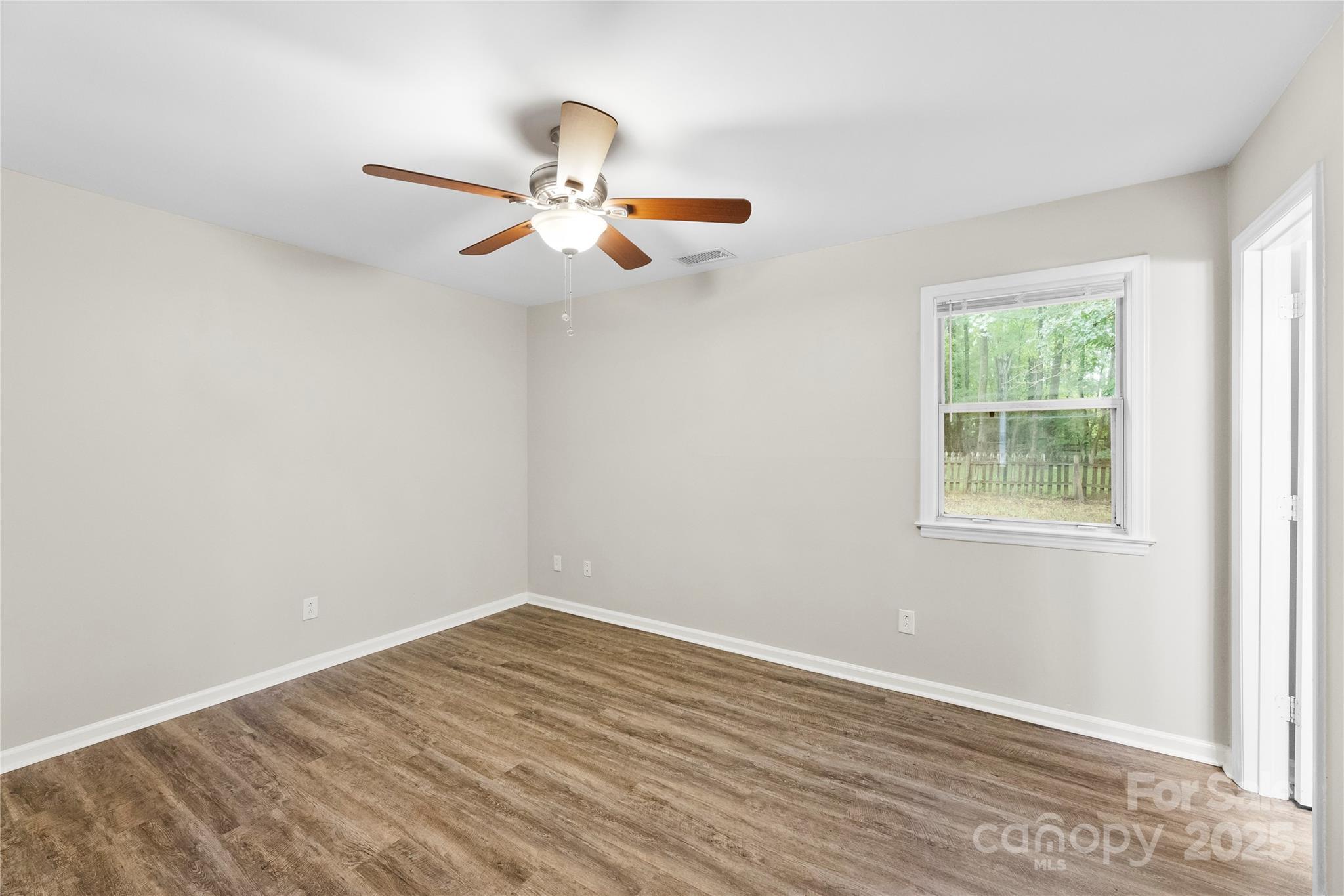 2713 Faircroft Way Monroe, NC 28110 - Photo 12 of 25 an empty room with a window and ceiling fan
