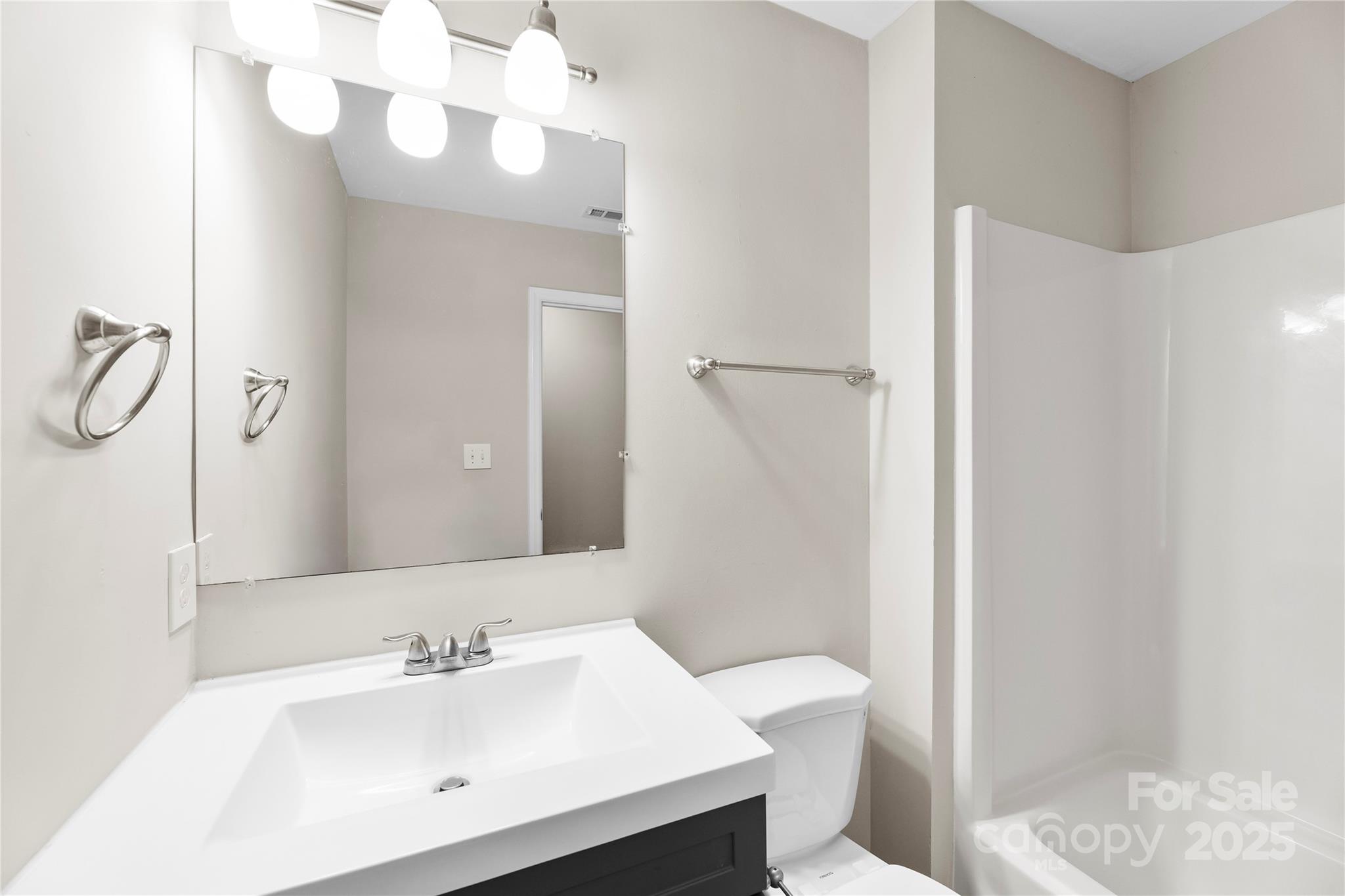 2713 Faircroft Way Monroe, NC 28110 - Photo 20 of 25 a bathroom with a sink a toilet and mirror