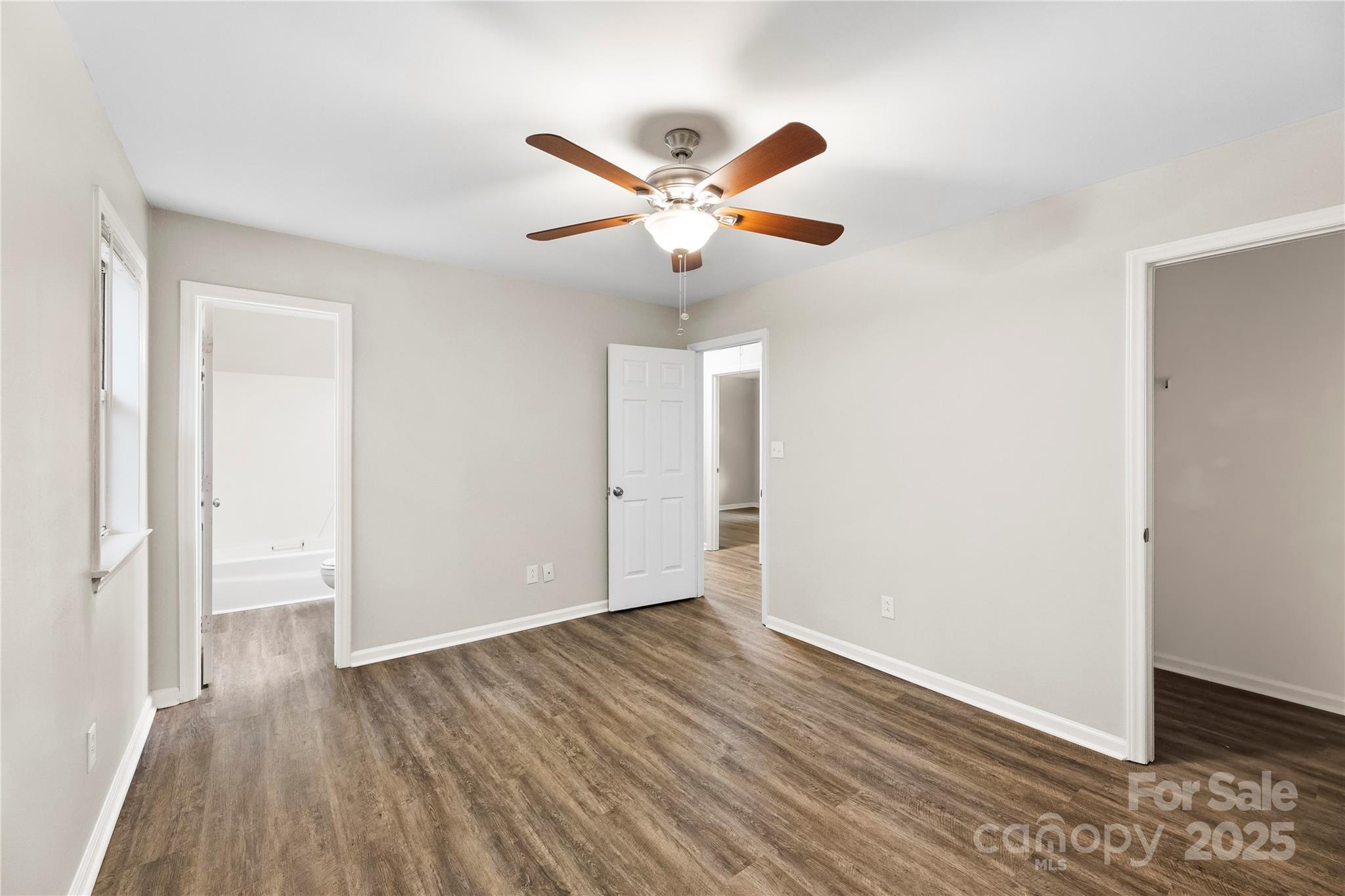2713 Faircroft Way Monroe, NC 28110 - Photo 4 of 25 an empty room with wooden floor and ceiling fan