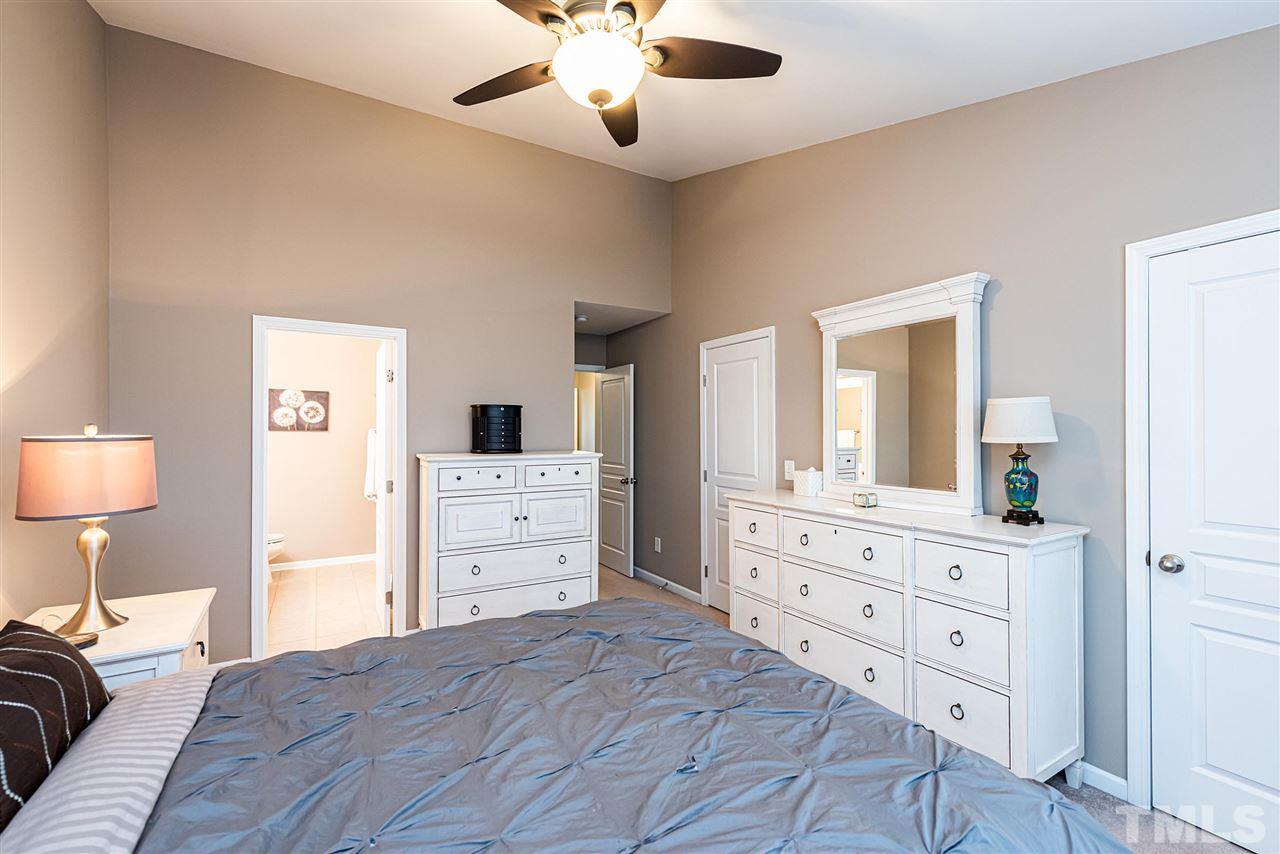 7749 Winners Edge Street Raleigh, NC 27617 - Photo 12 of 29 a bedroom with a bed and a dresser