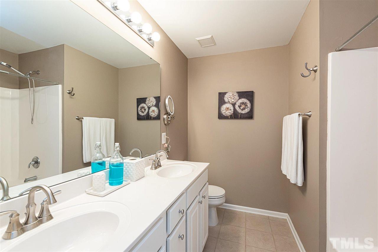 7749 Winners Edge Street Raleigh, NC 27617 - Photo 14 of 29 a bathroom with a sink vanity and a mirror
