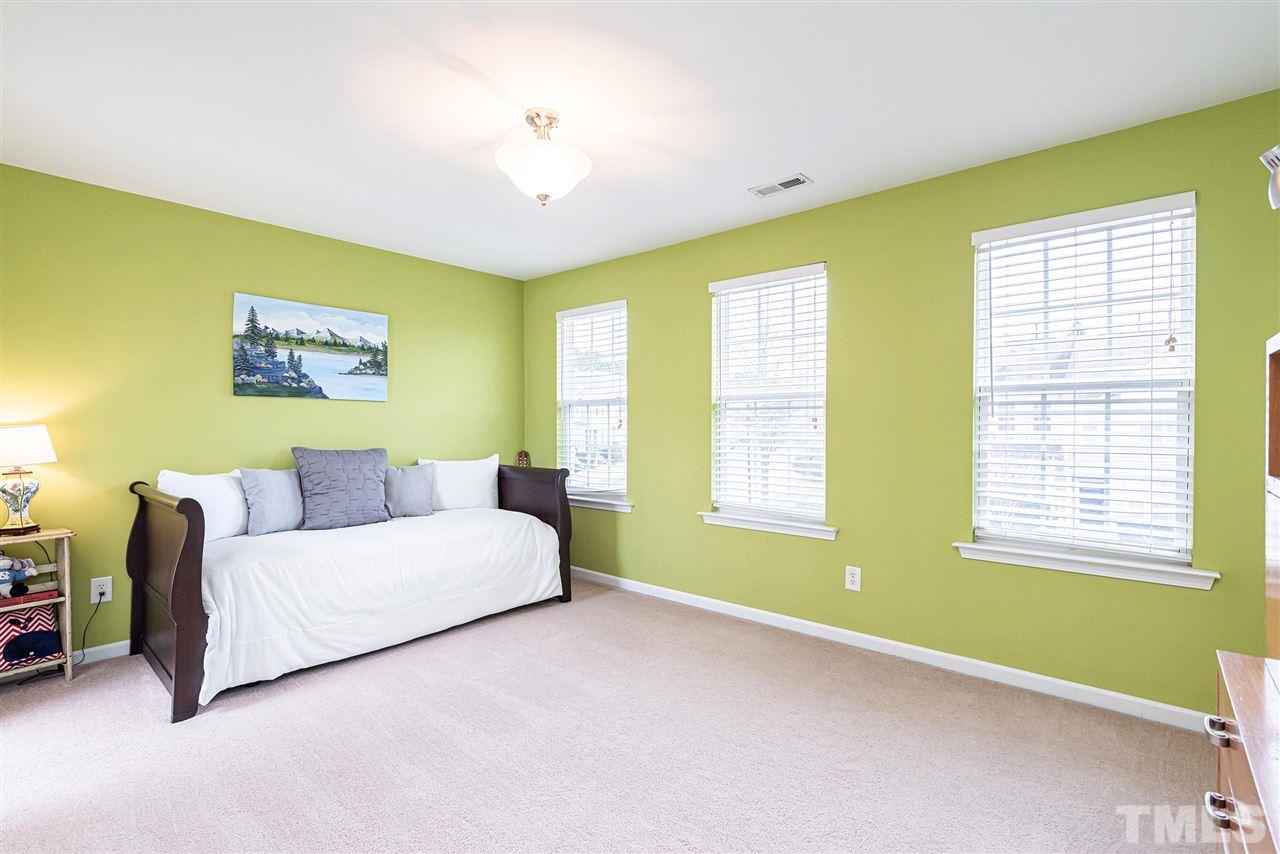7749 Winners Edge Street Raleigh, NC 27617 - Photo 16 of 29 a spacious bedroom with a bed and a couch