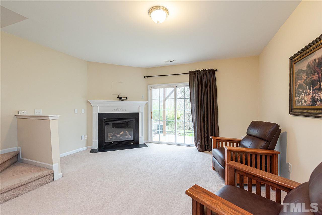 7749 Winners Edge Street Raleigh, NC 27617 - Photo 19 of 29 a bedroom with furniture and a fireplace