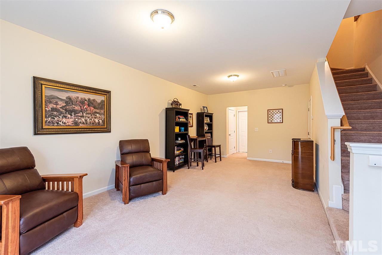 7749 Winners Edge Street Raleigh, NC 27617 - Photo 21 of 29 a living room with furniture and a flat screen tv