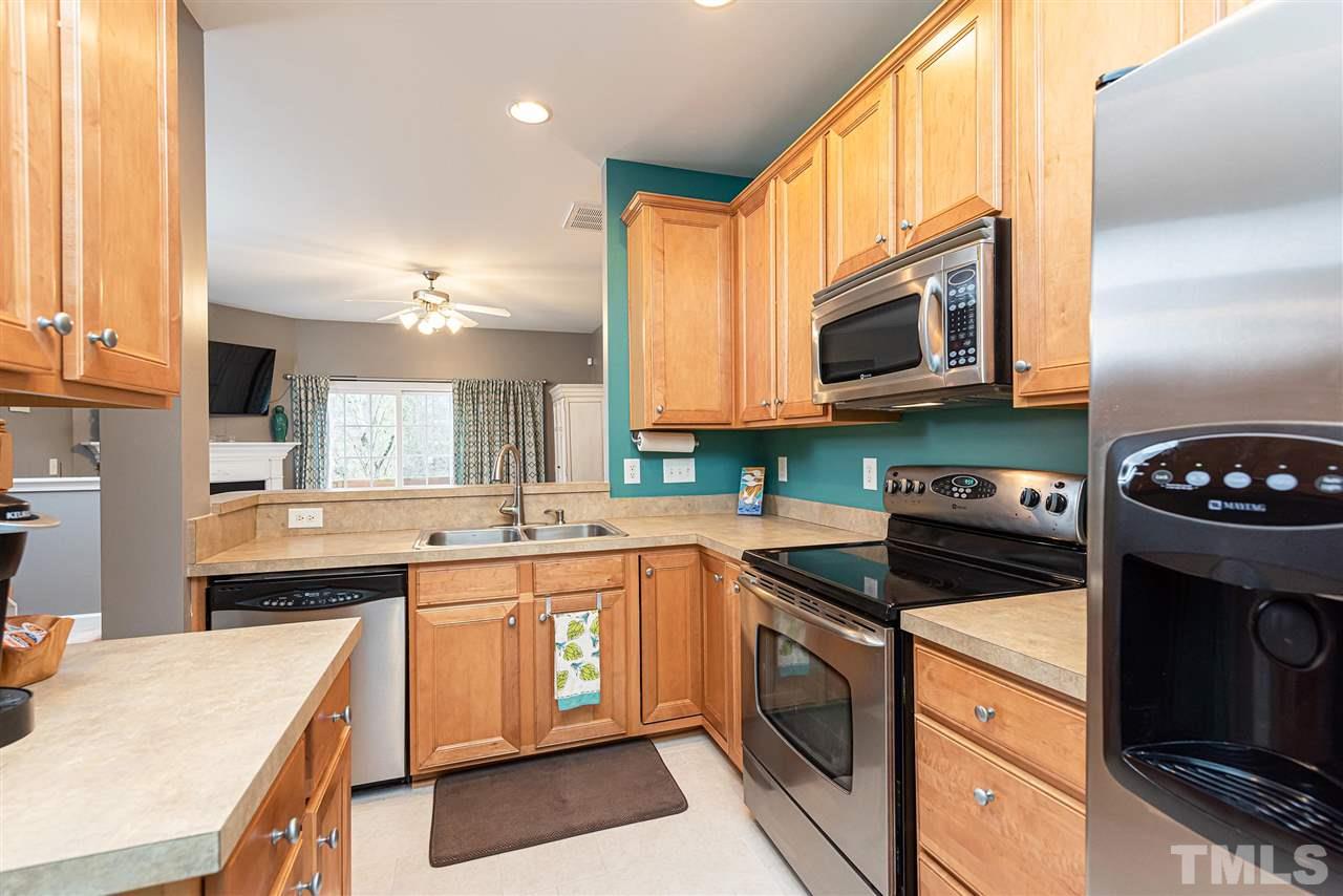 7749 Winners Edge Street Raleigh, NC 27617 - Photo 4 of 29 a kitchen with stainless steel appliances granite countertop a stove a sink and a microwave