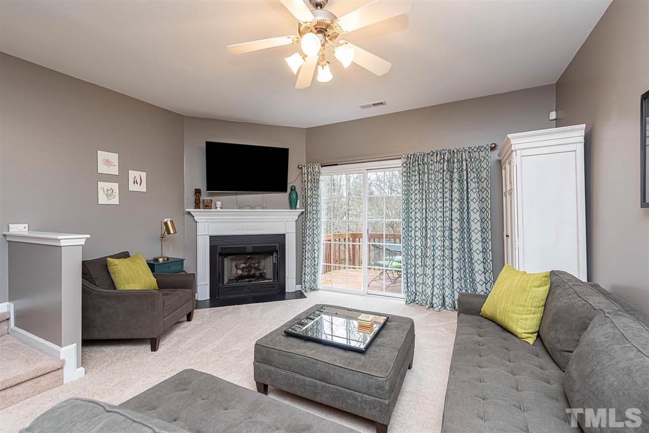 7749 Winners Edge Street Raleigh, NC 27617 - Photo 7 of 29 a living room with furniture a fireplace and a flat screen tv