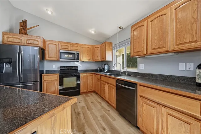 a kitchen with stainless steel appliances granite countertop a sink stove microwave and refrigerator