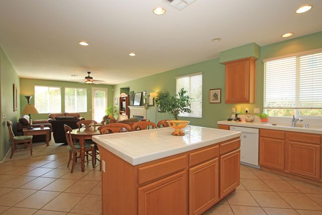 a view of a kitchen with kitchen island a sink a counter top space and living room view