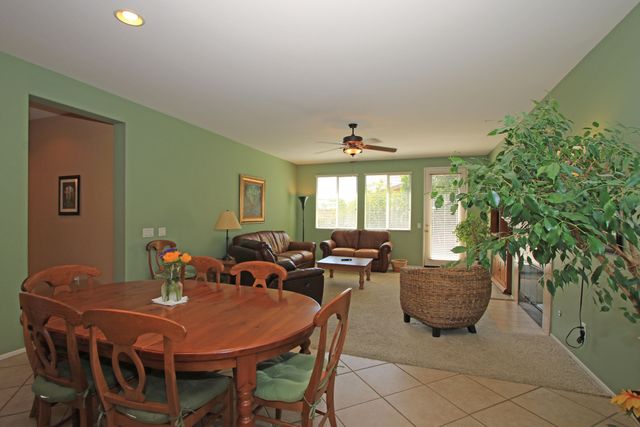 a living room with furniture kitchen view and a chandelier
