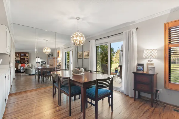a kitchen with a dining table chairs and white appliances