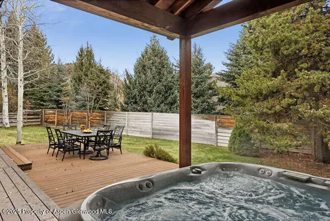 a view of a patio with table and chairs with wooden floor and fence