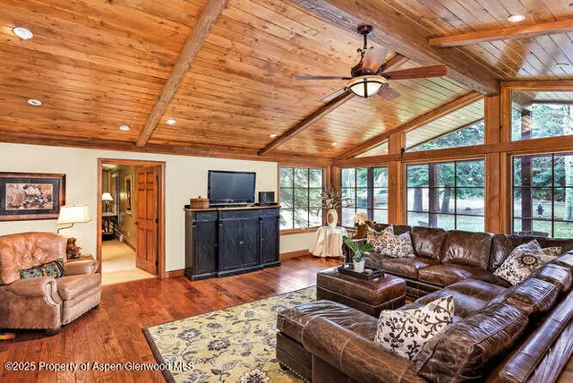 a living room with furniture a flat screen tv and a table