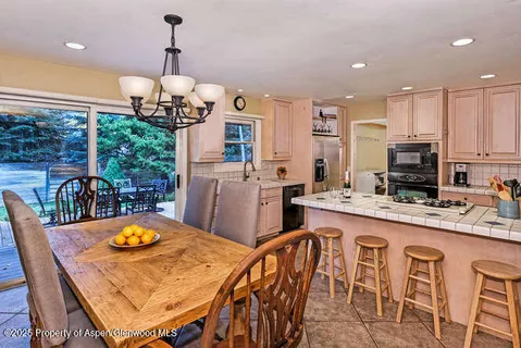 a kitchen with stainless steel appliances granite countertop a dining table chairs and granite counter tops