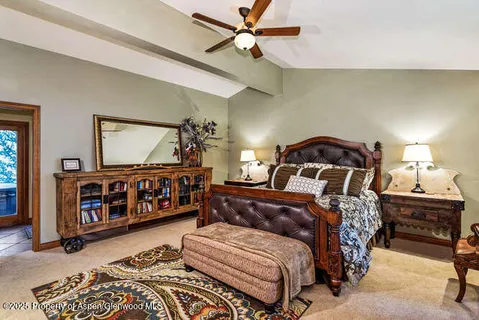 a bedroom with a bed a mirror on dresser and a chandelier