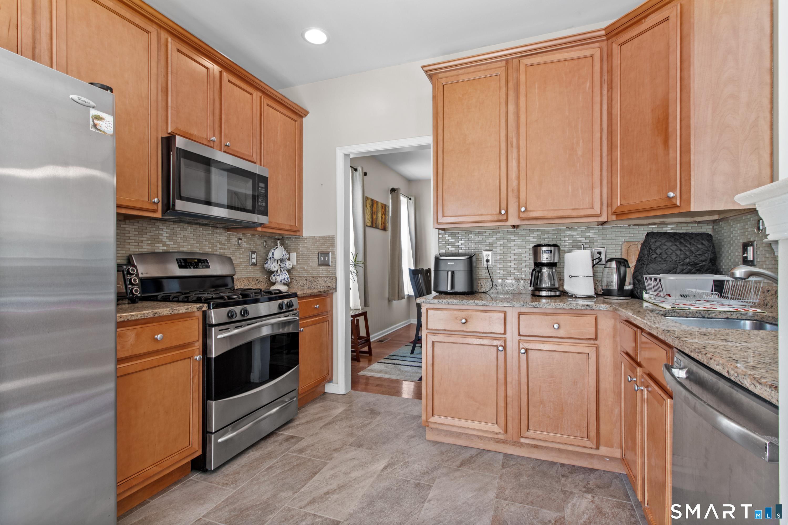 5 Haskins Road, Unit 5 Windsor, CT 06095 - Photo 24 of 40 a kitchen with stainless steel appliances granite countertop a stove top oven a sink and dishwasher
