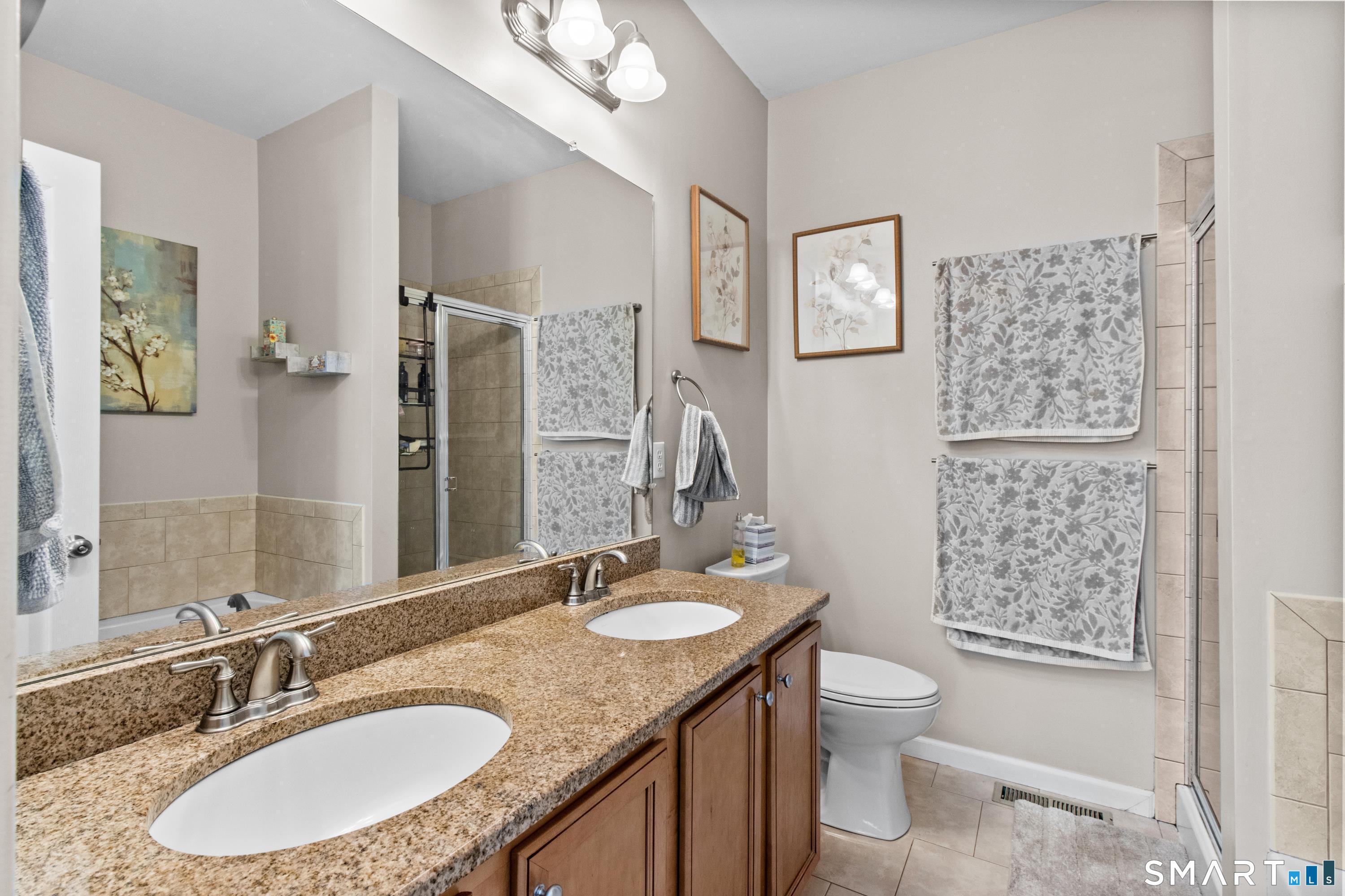 5 Haskins Road, Unit 5 Windsor, CT 06095 - Photo 26 of 40 a bathroom with a granite countertop sink toilet a mirror a vanity and shower