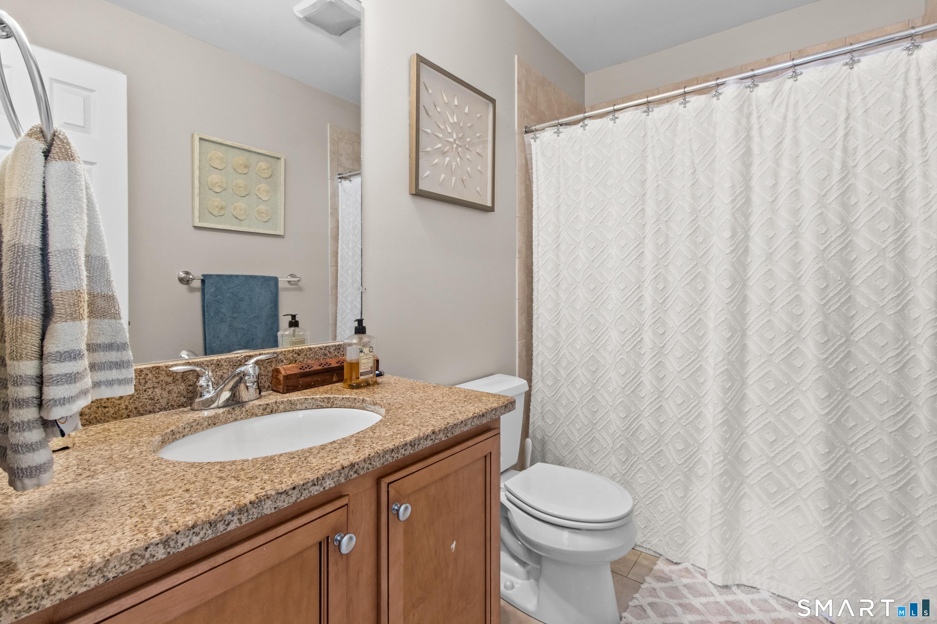 5 Haskins Road, Unit 5 Windsor, CT 06095 - Photo 38 of 40 a bathroom with a granite countertop sink and a mirror