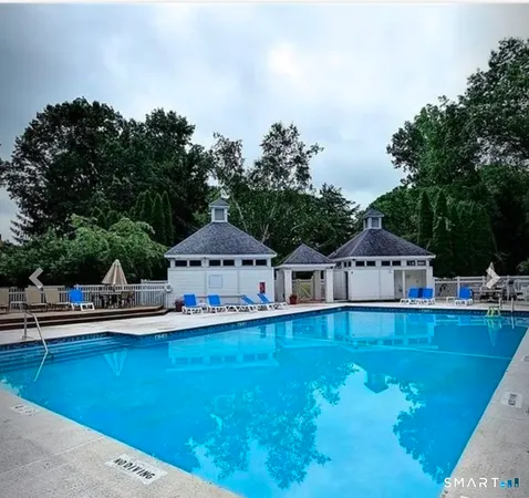 a front view of a house with swimming pool and next to trees
