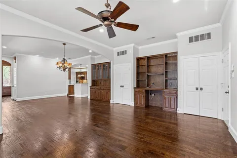 a view of a livingroom with a flat screen tv wooden floor and a ceiling fan
