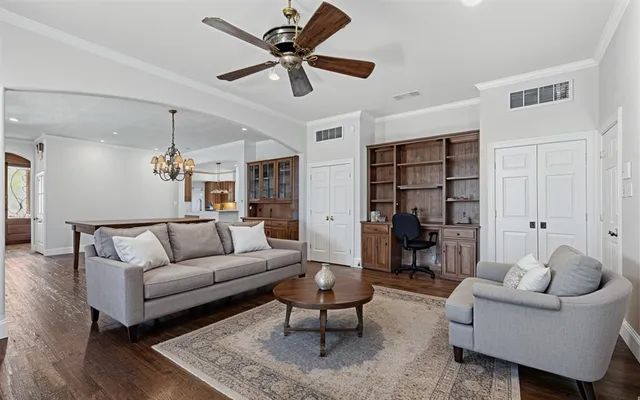 a living room with furniture a rug and a chandelier