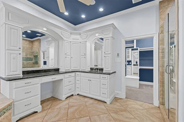 a large white kitchen with granite countertop a sink and dishwasher
