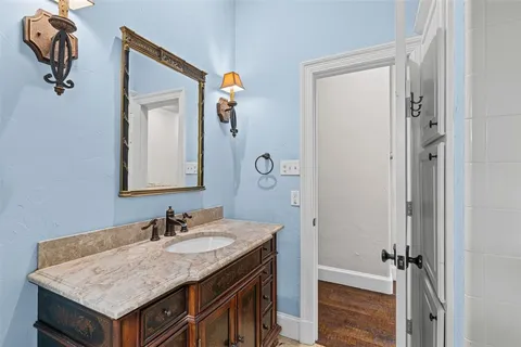a bathroom with a granite countertop sink and a mirror