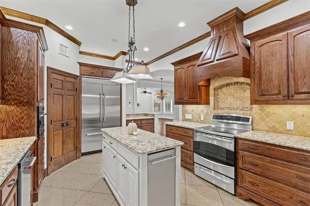 a kitchen with stainless steel appliances granite countertop a sink and a refrigerator