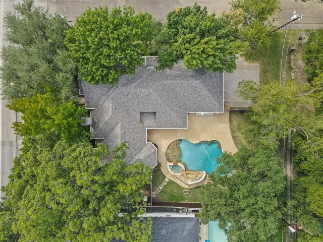 an aerial view of a house with garden space and a fountain