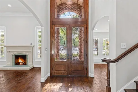 a view of a livingroom with wooden floor fireplace and windows